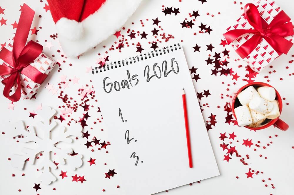 santa hat beside note pad with goals listed for holidays