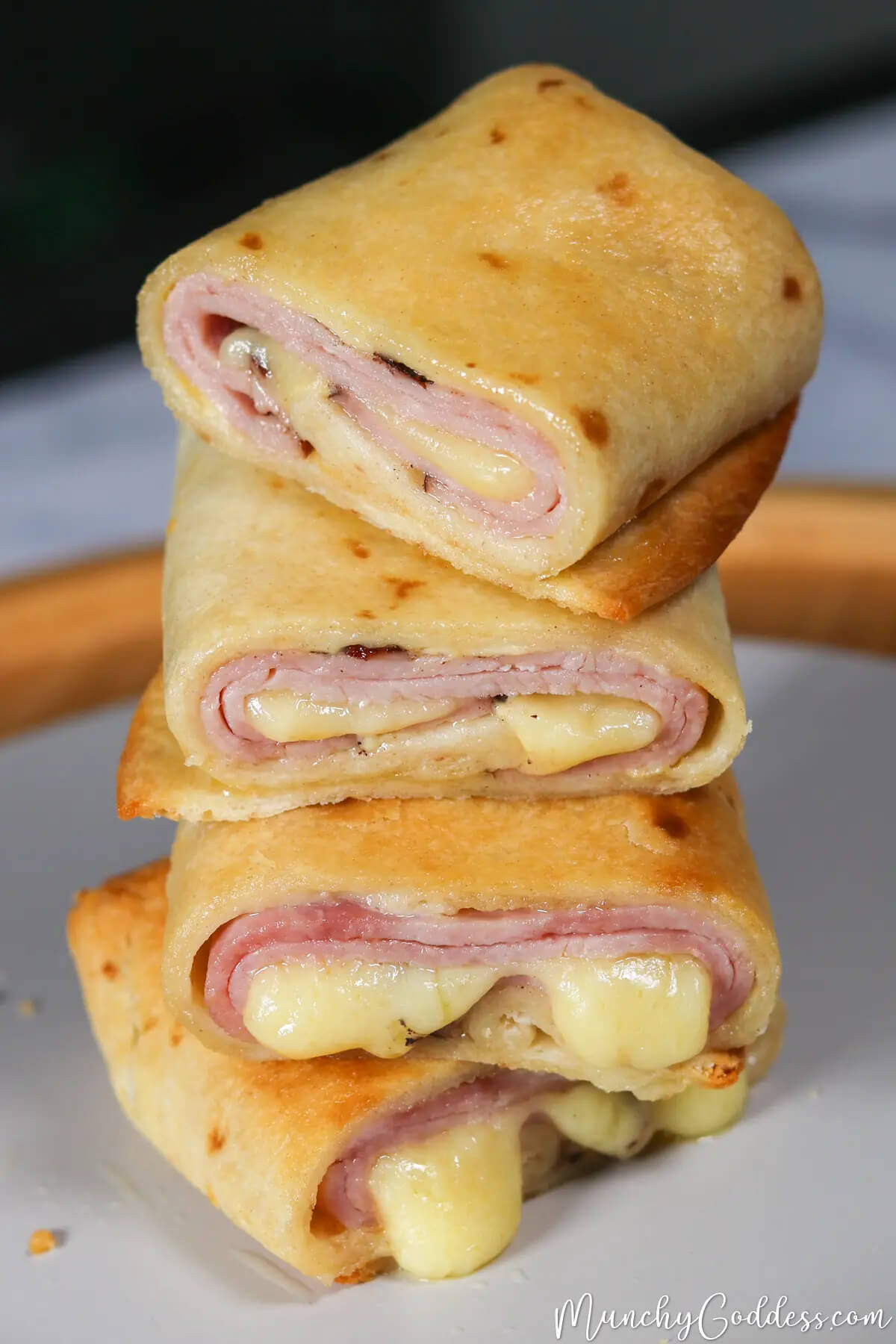 hot hame and cheese rolls cut in half and stacked.